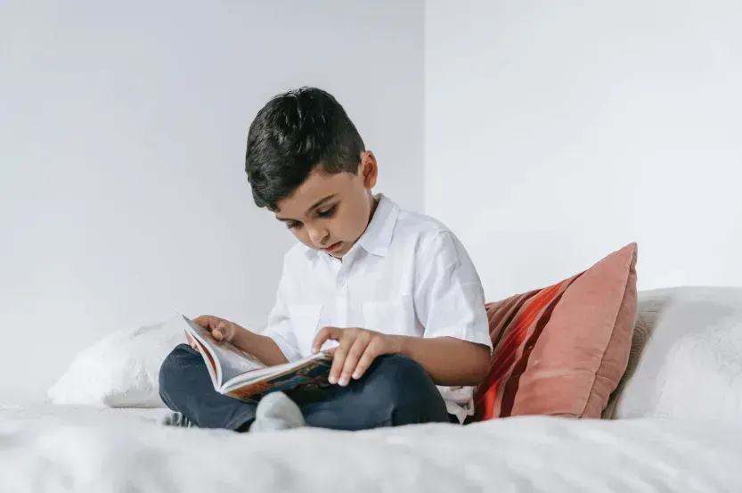 Criança concentrada lendo um livro